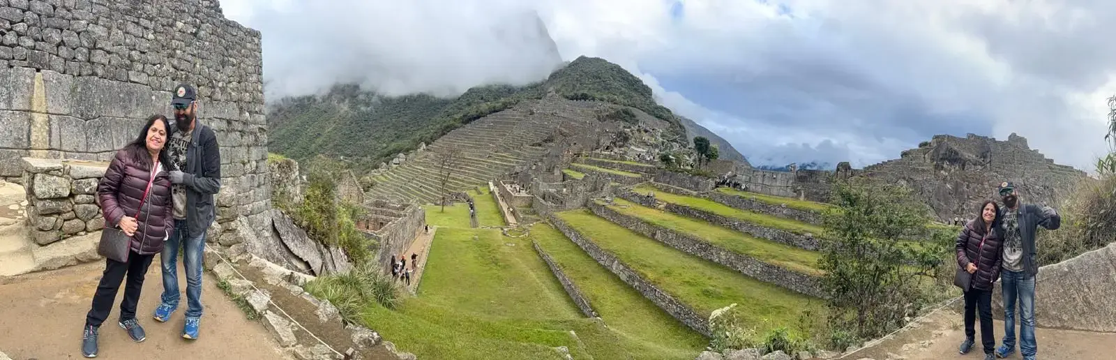 Machu Picchu terraces and stone citadel with a couple captured in two different foreground spots during a tour, Peru.