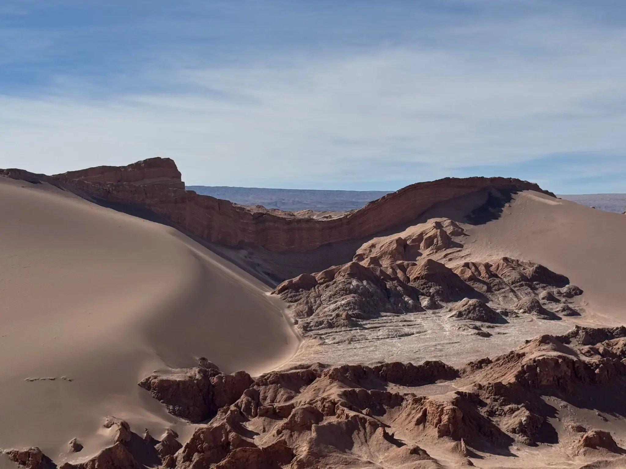 Valle de la Luna sand dunes and layered rock formations in the Atacama Desert, Chile.
