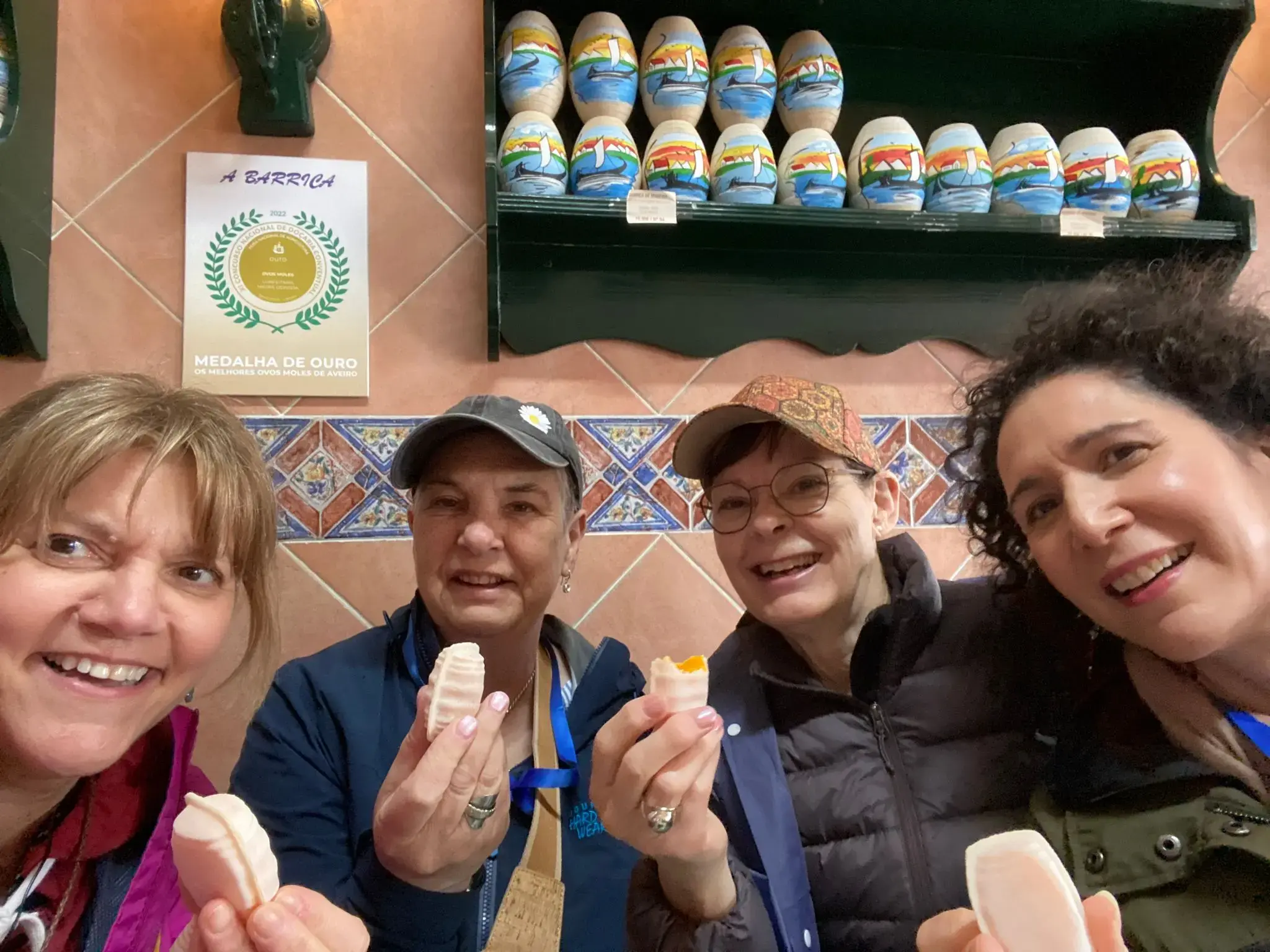 Four women sampling ovos moles pastries inside a shop in Aveiro, Portugal