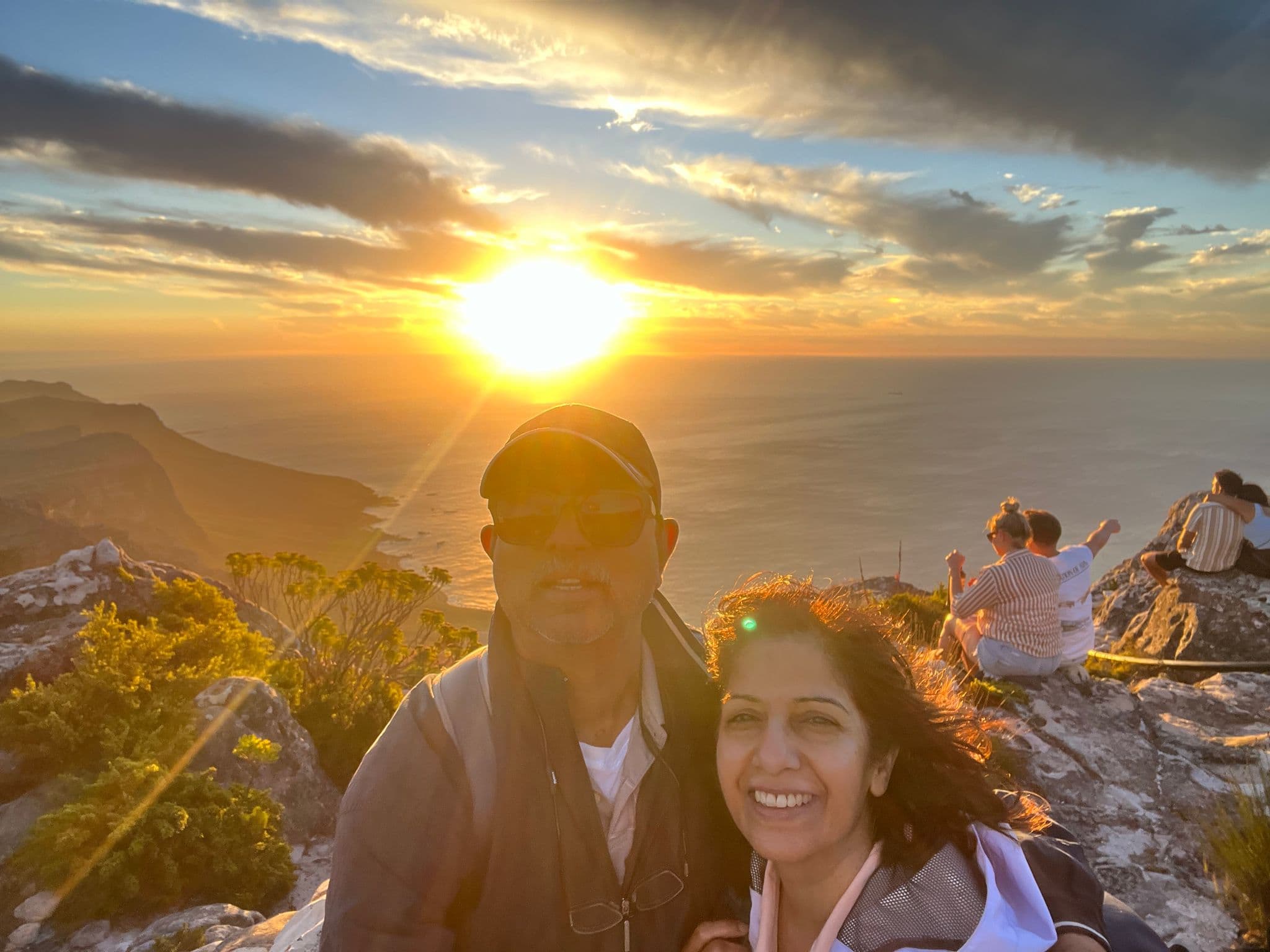 Table Mountain sunset with a couple taking a selfie overlooking Cape Town, South Africa.