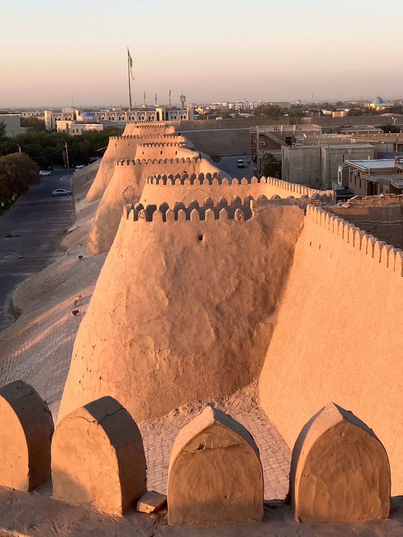 Mud-brick defensive walls of Itchan Kala in Khiva, Uzbekistan, seen from the ramparts at sunset.