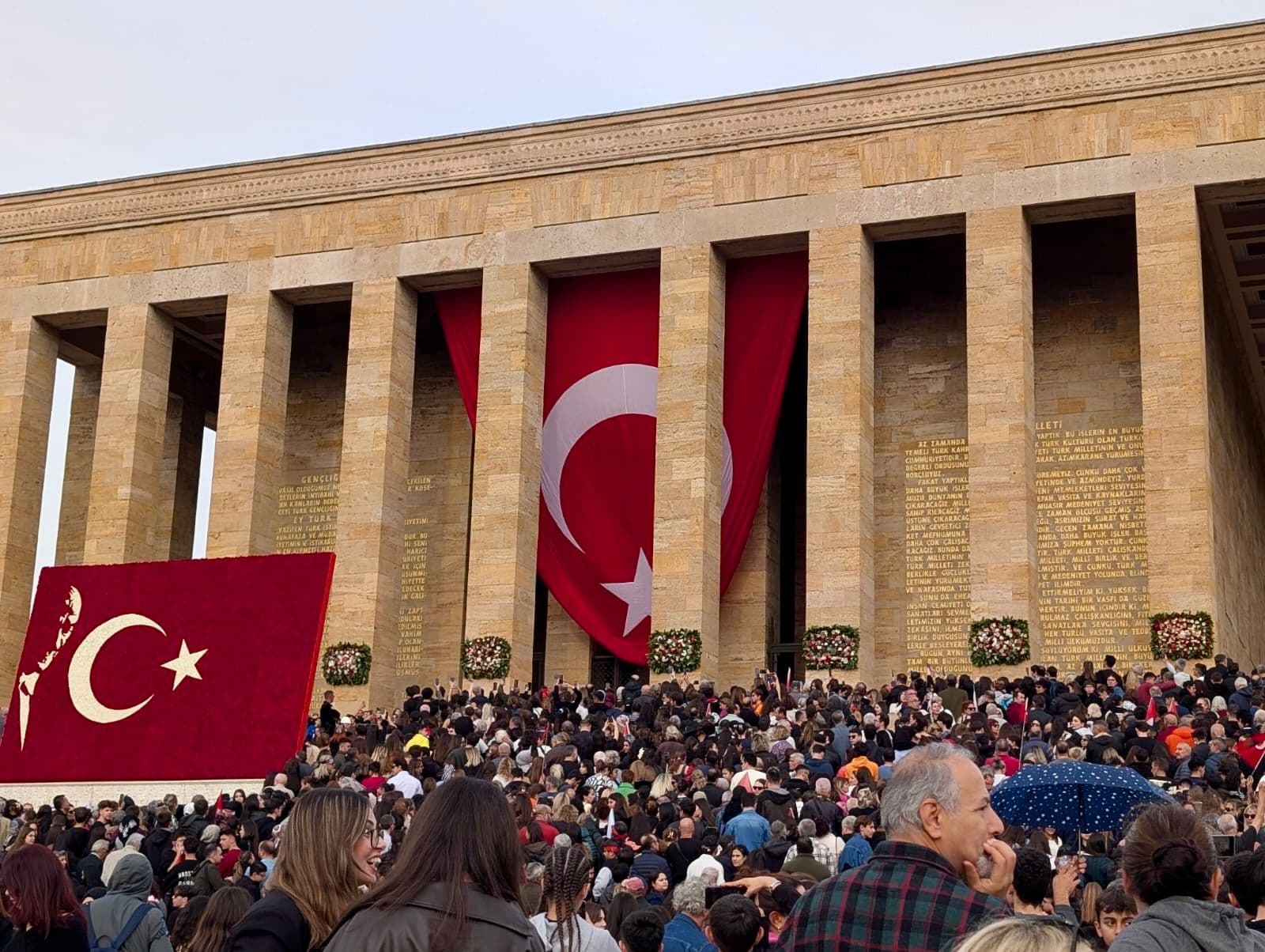 An?tkabir with a large Turkish flag between its columns and a dense crowd gathered on the forecourt in Ankara, Turkey.