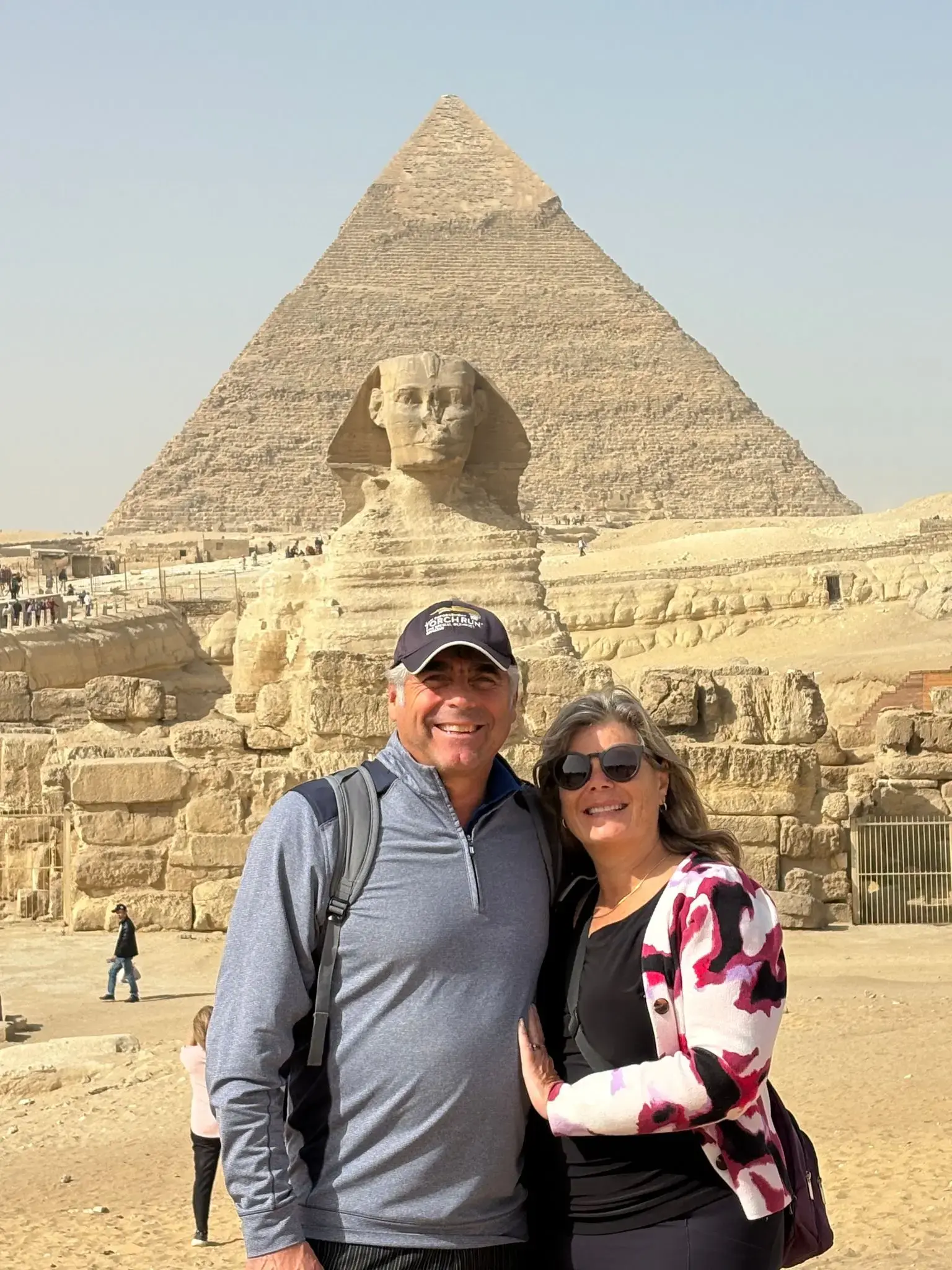 Great Sphinx of Giza with a smiling couple posing in front on the Giza Plateau near Cairo, Egypt.