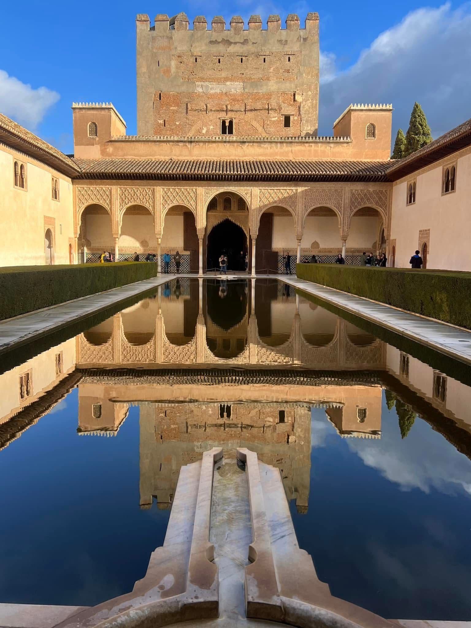 Court of the Myrtles at the Alhambra in Granada, Spain, with the Nasrid Palace facade reflected in the long central pool.