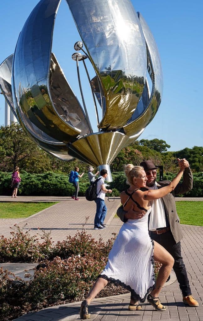 Floralis Genérica metal flower sculpture with a couple dancing tango on the plaza, Buenos Aires, Argentina.