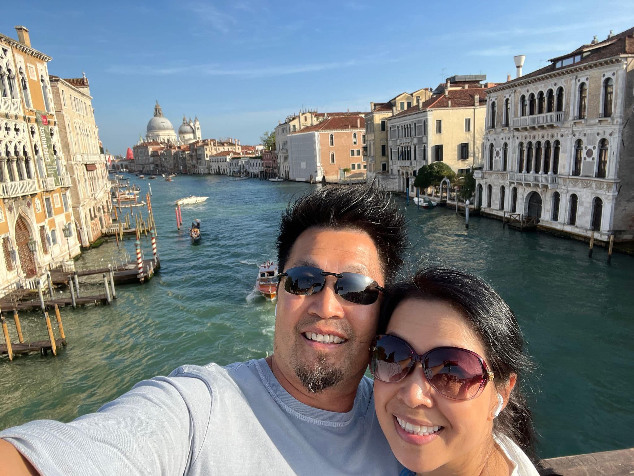 Grand Canal and Basilica di Santa Maria della Salute seen from the Rialto in Venice, Italy, with a couple taking a selfie.