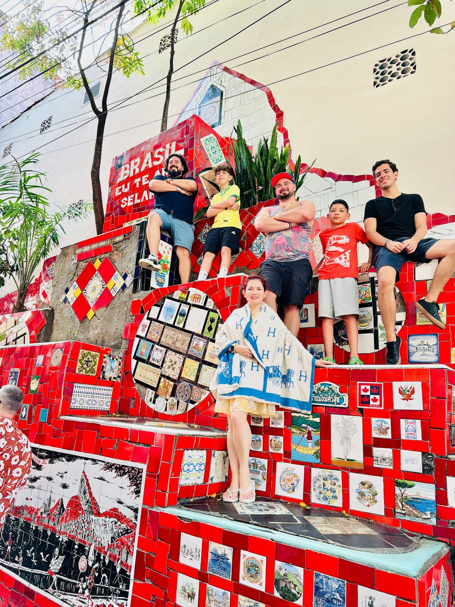 Selarón Steps mosaic stairway with a group of travelers posing on the red tiled steps in Rio de Janeiro, Brazil.