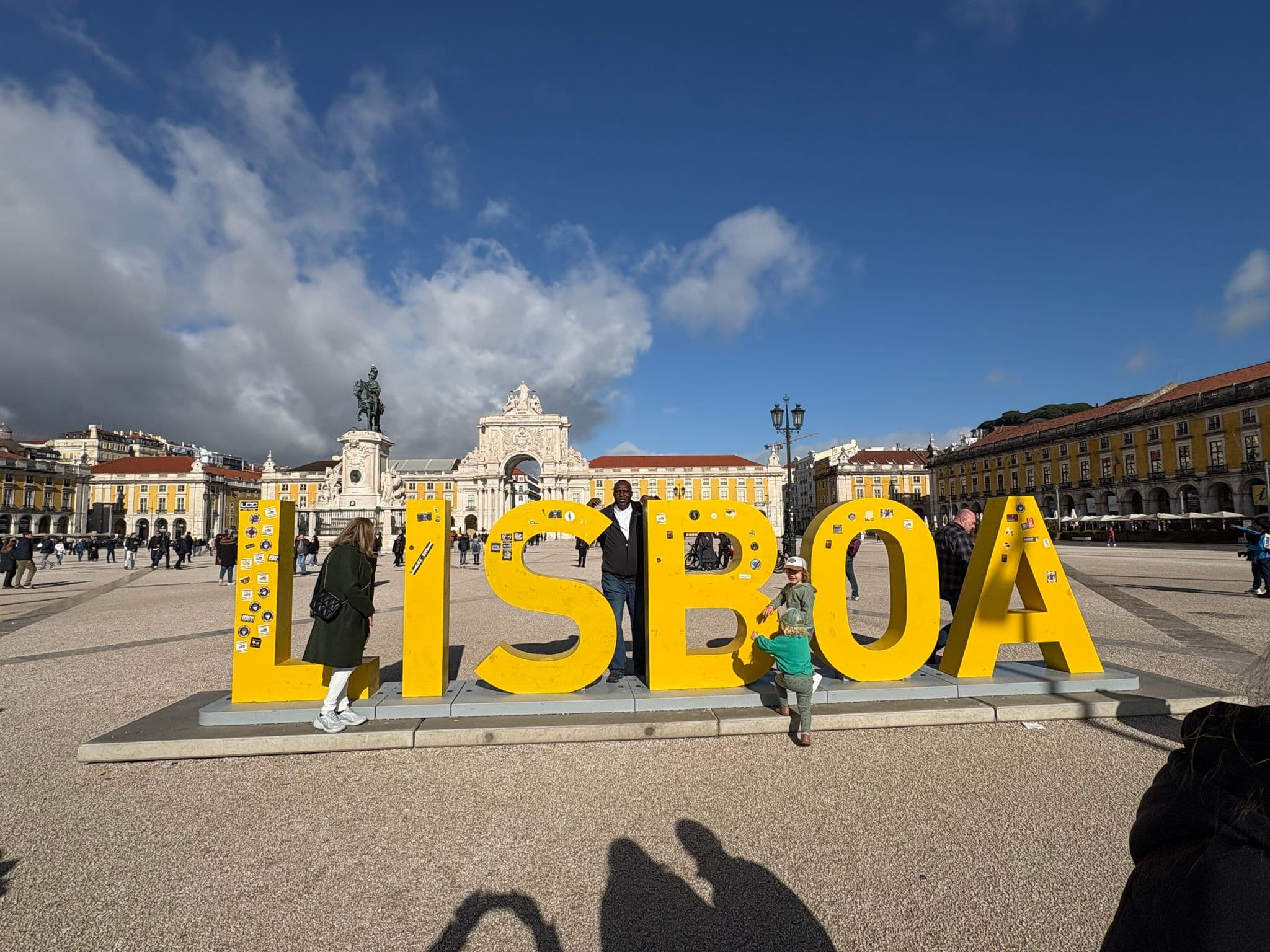 LISBOA sign in Praça do Comércio with people posing and walking in front of the Arco da Rua Augusta, Lisbon, Portugal
