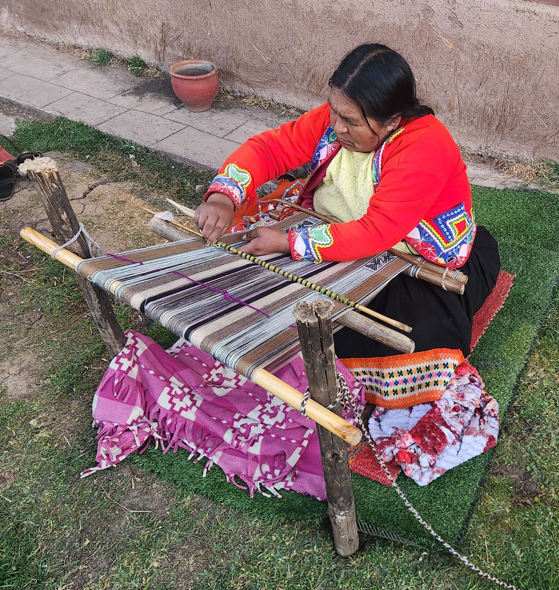 A woman weaving on a backstrap loom on a farm outside Cusco, Peru.