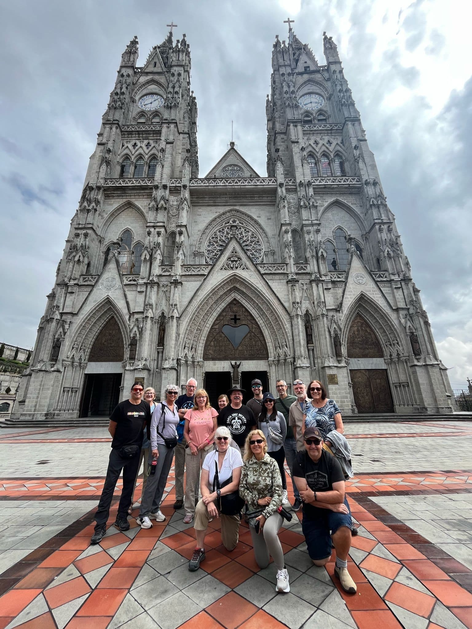 Basílica del Voto Nacional in Quito, Ecuador with a tour group posing on the patterned plaza in front of the cathedral