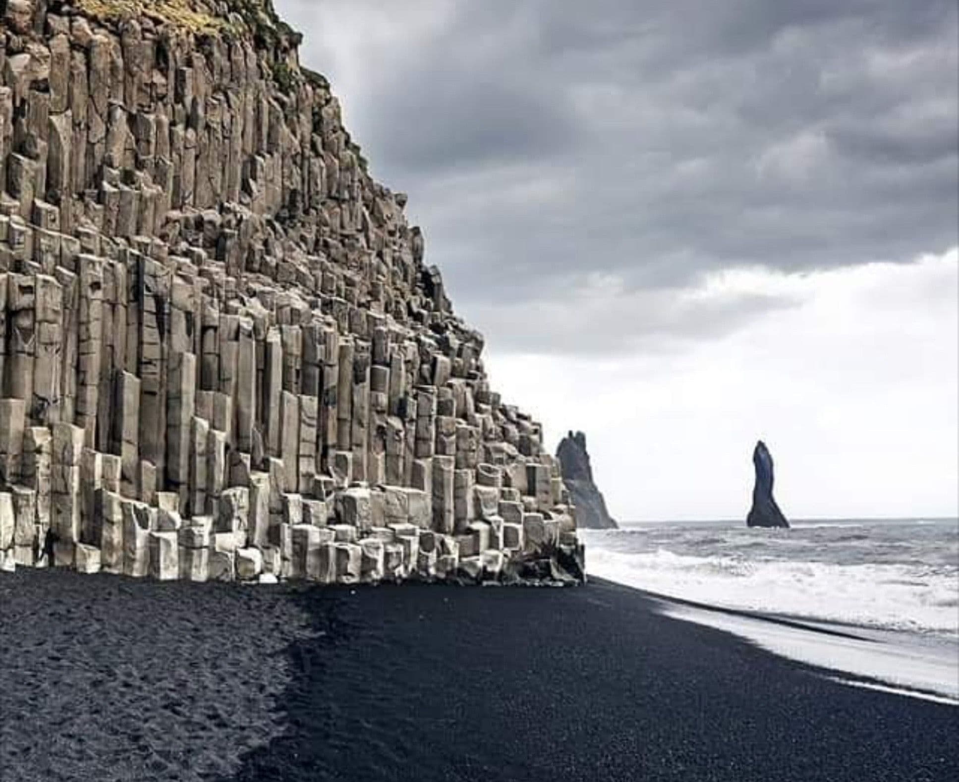 Reynisfjara black sand beach with geometric basalt columns and the Reynisdrangar sea stacks off southern Iceland