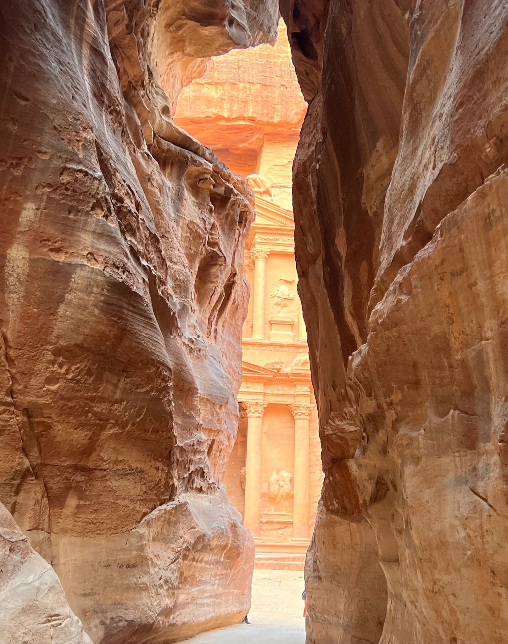 Al-Khazneh (the Treasury) seen at the end of the Siq, framed by towering sandstone walls in Petra, Jordan.