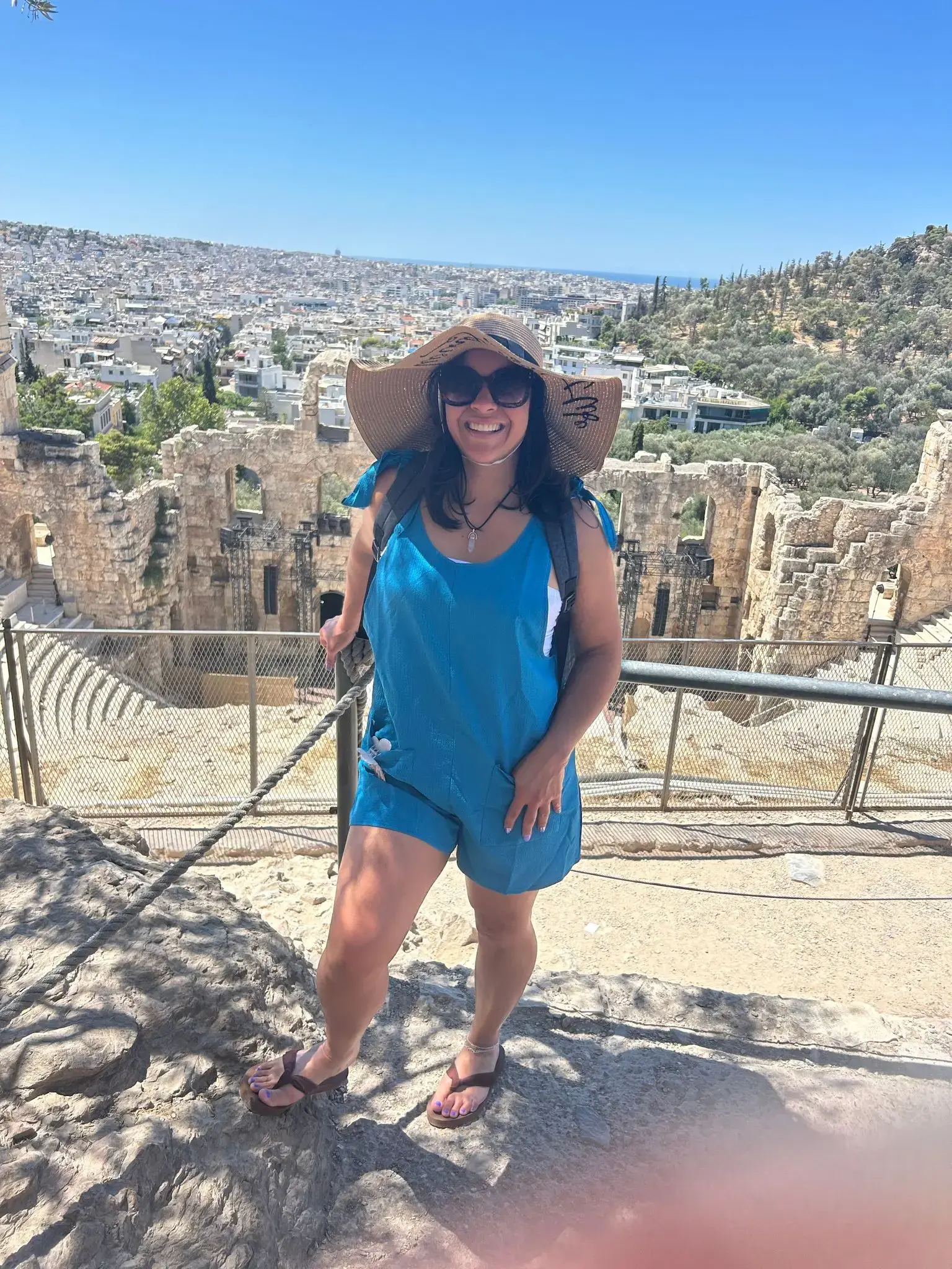 Odeon of Herodes Atticus amphitheater with a woman posing on a lookout, Athens, Greece.