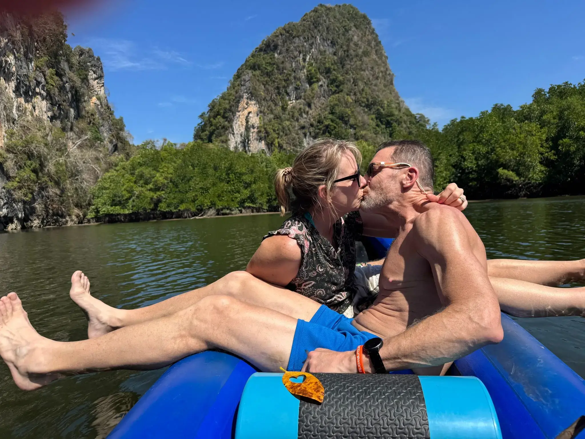 Phang Nga Bay limestone karst near James Bond Island with a couple kissing in a canoe on the water, Phuket, Thailand.
