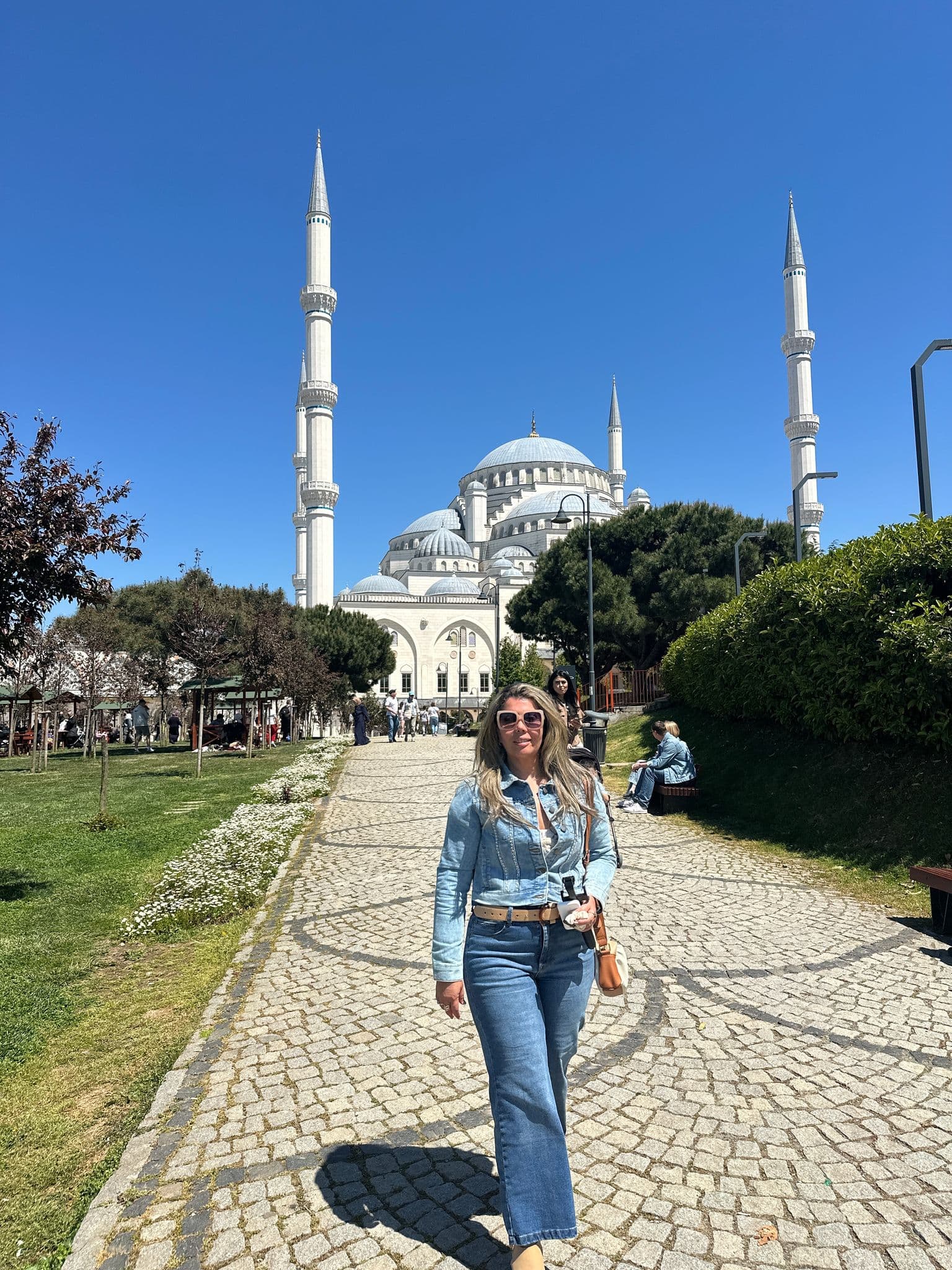 Çaml?ca Mosque in Istanbul with a woman walking along a cobbled path in the foreground.