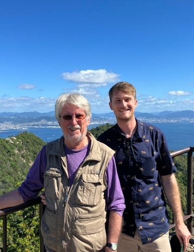 Gary Armstrong and his father enjoying the scenic views of Japan, with iconic landmarks in the background.