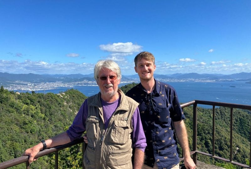 Gary Armstrong and his father enjoying the scenic views of Japan, with iconic landmarks in the background.