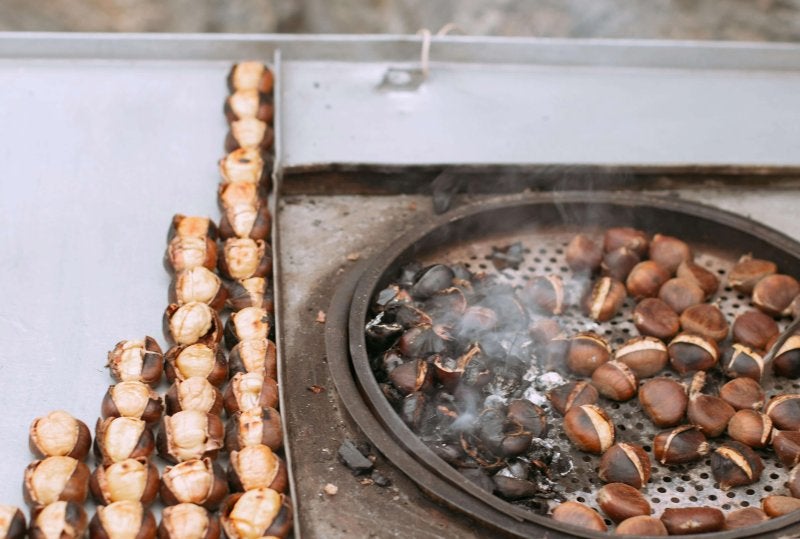 Roasted chestnuts on tray at autumn market in Barcelona