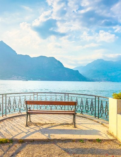 Bench on lakefront in Como Lake landscape. Bellagio Italy