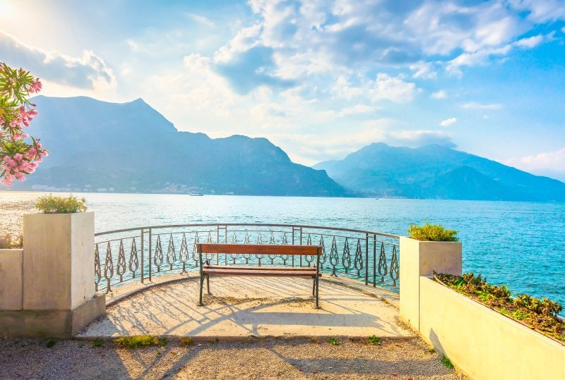 Bench on lakefront in Como Lake landscape. Bellagio Italy