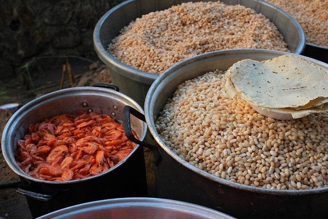 Colorful clay vessels filled with authentic Mexican ingredients including dried chiles and grains