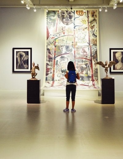 Modern art museum gallery with visitor viewing colorful paintings