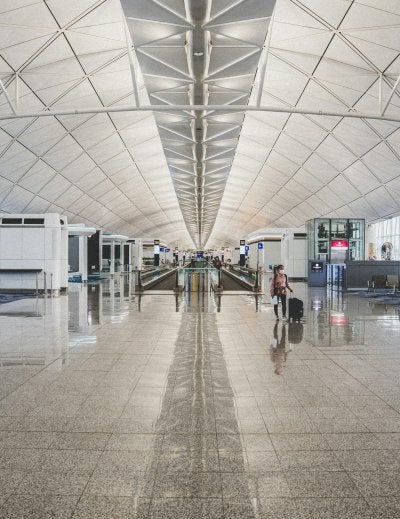 Modern airport terminal interior with departure gates and travelers walking