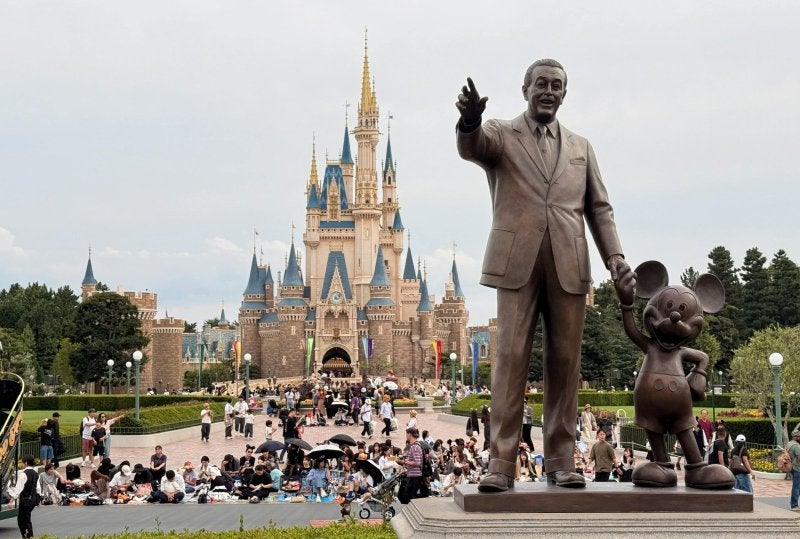 Statue of Walt Disney and Mickey Mouse in front of Cinderella Castle, Tokyo Disneyland.