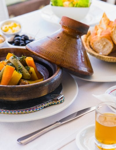 Close up moroccan food tajine, mint tea, olive and bread. Focus on tajine.