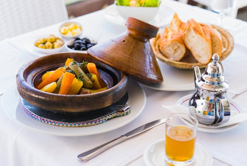 Close up moroccan food tajine, mint tea, olive and bread. Focus on tajine.