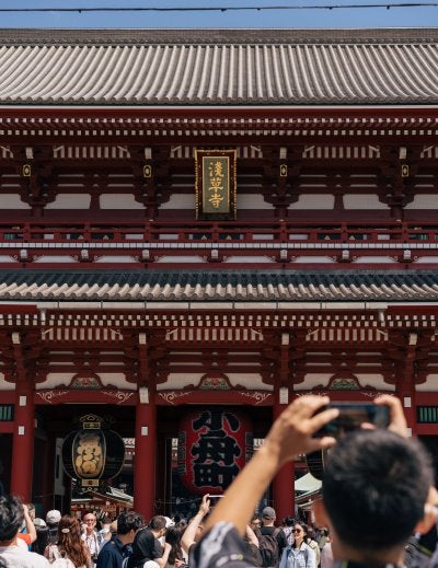 The Senso-ji temple in Asakusa, Tokyo, showing traditional Japanese Buddhist temple architecture with paper lanterns and the historic gate area of one of Japan's most visited shrines
