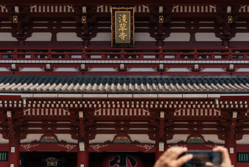 The Senso-ji temple in Asakusa, Tokyo, showing traditional Japanese Buddhist temple architecture with paper lanterns and the historic gate area of one of Japan's most visited shrines