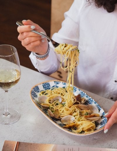 Capture of a gourmet seafood spaghetti meal paired with white wine.