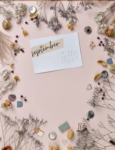 A minimalist September calendar surrounded by dried flowers and natural elements.