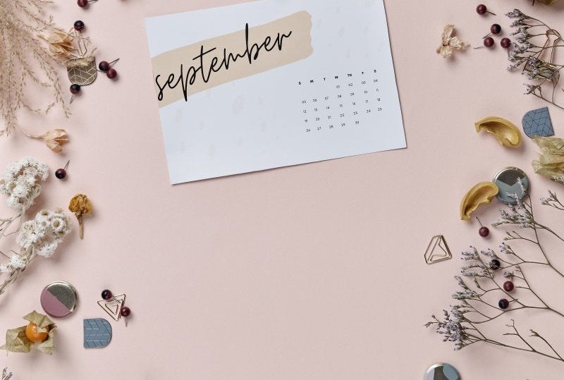 A minimalist September calendar surrounded by dried flowers and natural elements.